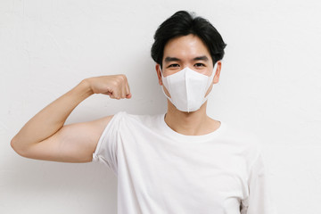 Young asian healthy male wearing medical face mask to protect corona virus, studio portrait.