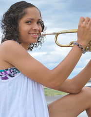 Female trumpet player expressions outdoors.