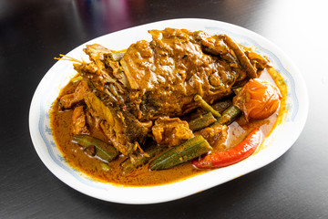 Serving of popular curry fish head with okra and tomato