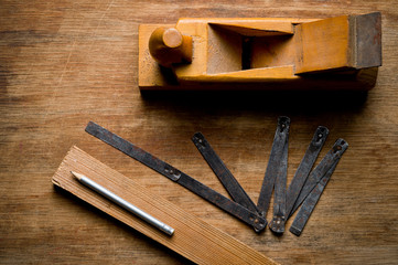 Measuring iron folding meter old, photographed on a shabby wooden surface.