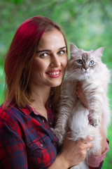 Woman with domestic cat portrait. Summer fashion shot with green blurred background.
