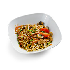 Fried udon noodles in a wok with slices of pork, carrots and mushrooms. Traditional asian food. Isolated on a white background.