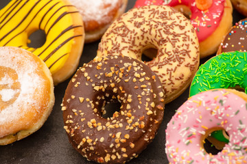 Dessert, Donuts, chocolate and strawberry circles, sugar and cream on Donuts and hot coffee cups, preparation for a break or party on the wooden table background.