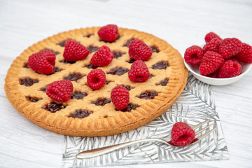 Dessert Raspberry Pie cake with strawberry or Fruit in a round bread for Break time or a party shot at the top view and copy space on a white wooden table.