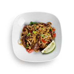 Fried udon noodles in a wok with beef, bell pepper and broccoli. Traditional asian food. Isolated on a white background.
