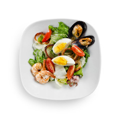 Seafood salad. Mussels, scallops, shrimp and squid with cherry, egg and sauce. Isolated on a white background.