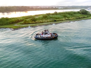 The patrol Panamanian tug boat guiding ships
