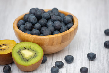Bio Fruit Blueberry in bowl wood health and diet with vitamin c in close-up on the wood table.