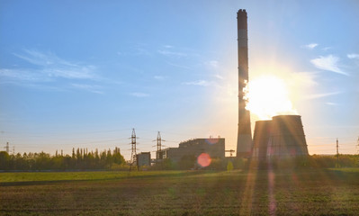 Open-type cooling towers of CHP combined heat and power station at sunset