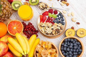 Group Fruits Breakfast mixed vegetables with salad bowl, nuts bowl, strawberry, banana, and pineapple, orange juice,  vitamin c in food  nature for health and diet in the top view on the wood table.