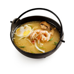 Traditional japanese miso soup with shrimp, mushrooms and egg on a white background