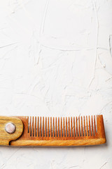 Wooden Sandalwood comb folding on a white textured background.