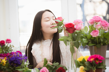 Woman Preparing to trim red and pink roses and beautiful flower arrangements in the home, flower arrangements with vase for gift-giving for Valentine's Day and Business in the family on the on table