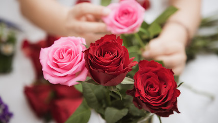 Woman Preparing to trim red and pink roses and beautiful flower arrangements in the home, flower arrangements with vase for gift-giving for Valentine's Day and Business in the family on the on table