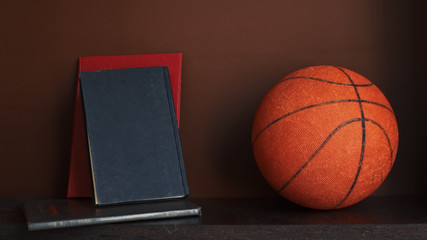 Basketball and books on wooden shelf