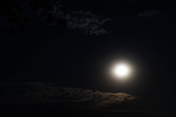 Full night moon on the background of passing clouds