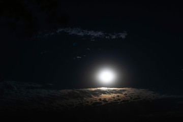 Full night moon on the background of passing clouds