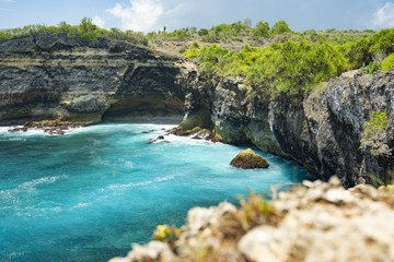 Fototapeta na wymiar (Selective focus) Stunning view of a rocky cliff bathed by a turquoise sea, Broken Beach, Nusa Penida. Nusa Penida is an island southeast of Bali, Indonesia.