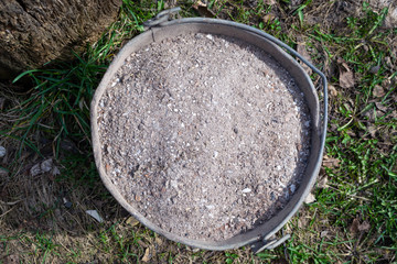 Bucket full of ashes as natural fertilizer, top view. Sustainable farming concept