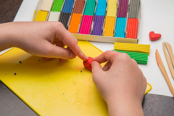 
child learns to sculpt from colored plasticine