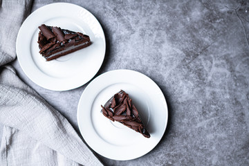 top view of 2 slices of sweet Chocolate cakes on the grey table, with copy space.