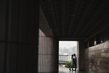 Romantic and happy caucasian couple in casual clothes walking at the city streets. Love, relationships, romance, happiness, urban concept. Man and woman holding hands and smiling.