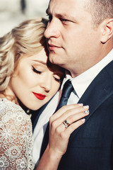 Bride and groom. Close-up portrait of a man in a suit and a woman with blond hair in a white dress on the wedding day.