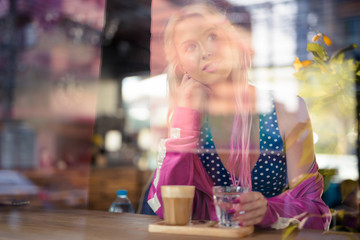 Happy young beautiful blonde woman relaxing at the coffee shop