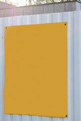 The yellow plate on the fence is empty for inscriptions.