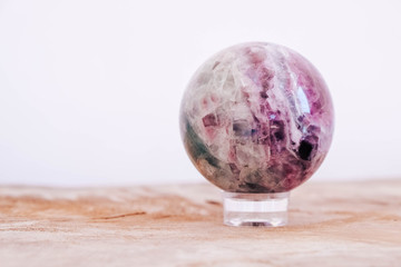 Crystal in the form of ball on a wooden table. Copy, empty space for text