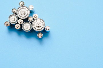 many used AA batteries on a blue background.