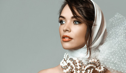 Portrait of young sensual romantic brunette woman in white stylish hood, jewelry beads accessories