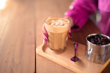 Hands of young woman drinking coffee and relaxing at the coffee shop