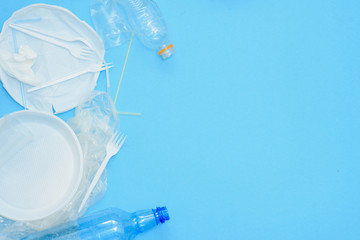 Plastic waste, plastic utensils on a blue background,flat lay. Say no to single use plastic. Ecology environmental care.Copy space for text.