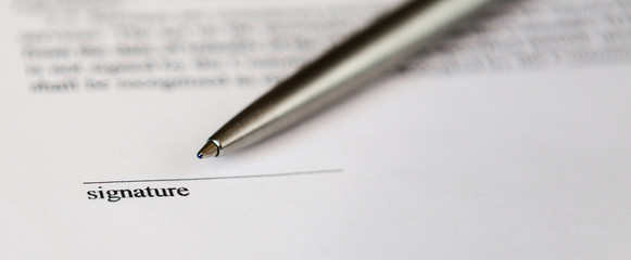 Space for signature on document and silver boll pen