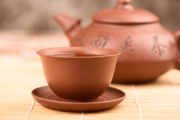 Selective focus Clay bowl with green tea on a clay saucer.