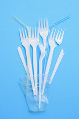 Plastic waste, plastic utensils on a blue background,flat lay. Say no to single use plastic. Ecology environmental care.Copy space for text.