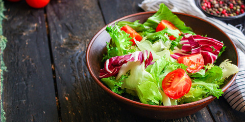Healthy salad, leaves mix salad (mix micro greens, cucumber, tomato, onion, other ingredients) keto or paleo diet. food background. copy space 