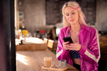Young beautiful blonde woman using phone at the coffee shop