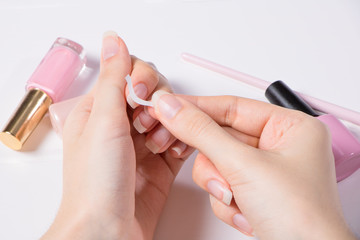 Manicure. A woman glues stickers on her nails for French manicure. The girl applies nail Polish....