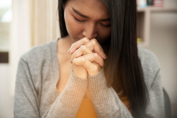 Pray and bible concept. Asian female praying, hope for peace and free from coronavirus, Hand in hand together by woman, believes and faith in christian religion at church.