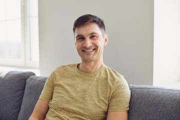 Businessman in casual t-shirt serious looking at the camera at home in the office