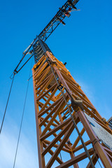 Fototapeta na wymiar Turmdrehkran auf einer Baustelle in Deutschland, fotografiert von unten mit blauem Himmel.