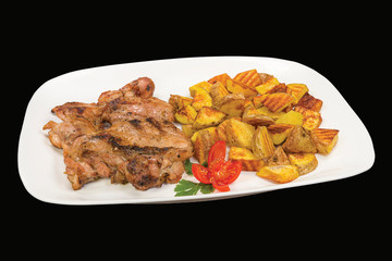 Tasty chicken steak served with boiled potatoes in a plate, isolated on black background.