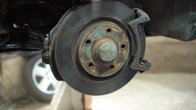 Brake disk of the car. Maintenance in the car service. Repair of the brake mechanism.