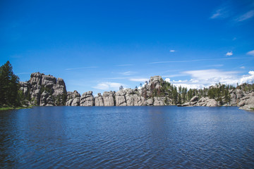 Sylvan lake in Custer state park black hills United States of America. Blue lake and blue sky with rocks and green trees. Travel background with nature view on lake South Dakota national forest.