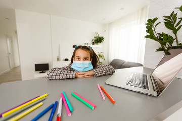 Fototapeta na wymiar Pretty stylish schoolgirl studying homework math during her online lesson at home, social distance during quarantine, self-isolation, online education concept, home schooler