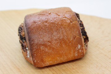 Delicious bob bun with poppy is located on a wooden surface