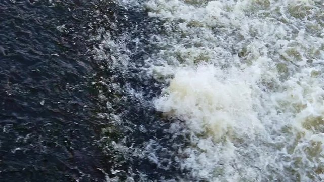 Bubbling stream of water on height difference of river, slow motion.