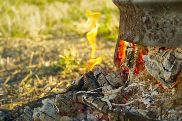 coals in a metal barrel on backyard. Smoldering fire in a round metal barrel after burning dry branches.